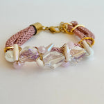 This Pink Crystal Bracelet features a delicate baby pink braided rope adorned with sparkling crystal beads.